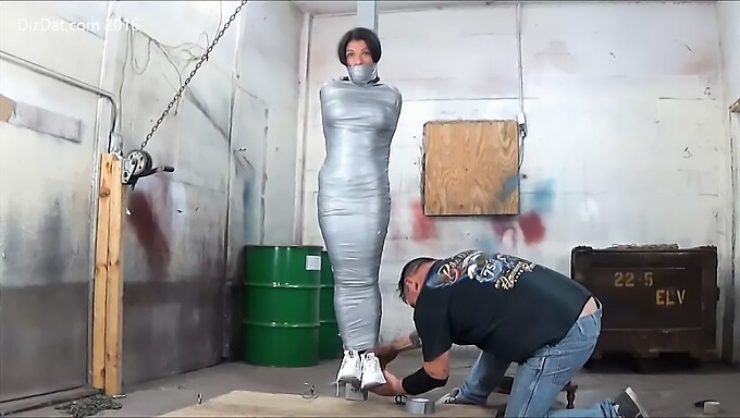 Busty European Woman Restrained With Tape On A Pole For Erotic Play